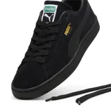 Championes urbanos Puma modelo Suede Classic, color negro total, confeccionados en gamuza con suela de goma y detalle de logo dorado en el lateral.