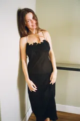 Vestido midi semitransparente de viscosa, con escote redondo y detalles de nervios marcados. Presenta tirantes finos dobles que se cruzan en la espalda y aplicaciones de bordados florales a tono en la parte superior.