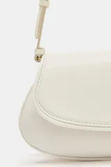 Bolso de hombro color crudo con diseño estructurado, solapa frontal, cierre de botón imantado y asa regulable.