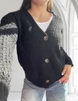 Saco de lana negro con textura de punto, escote en V y cierre frontal con botones.