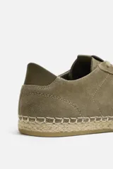 Zapatilla de cordones tipo alpargata color caqui, con capellada de piel serraje y suela de yute.