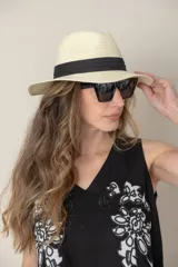 Sombrero de paja color beige con ala ancha y cinta negra decorativa.