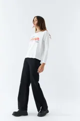 Remera blanca de algodón con mangas largas, cuello redondo y estampado con la frase 'look deeper always true art'.