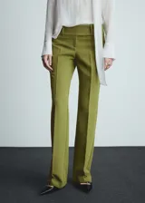 Pantalon de vestir de tiro bajo con diseño acampanado, confeccionado en tejido con acabado liso. Cuenta con trabillas en la cintura, cierre oculto de botón, gancho y cremallera, y bolsillos de ribete en la parte posterior.