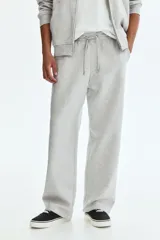 Pantalón deportivo en felpa pesada de mezcla de algodón con interior cepillado suave. Modelo de corte holgado con cintura elástica revestida, cordón de ajuste y bolsillos laterales.