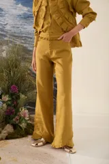 Pantalón morado de corte acampanado con volados decorativos en la cintura y en el ruedo.