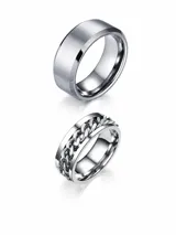 Conjunto de dos anillos de acero inoxidable en color plateado. Uno de los anillos presenta un diseño liso con acabado mate, mientras que el otro incorpora un detalle central de cadena giratoria.