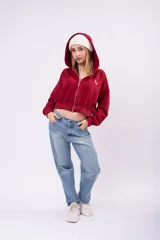 Campera cropped de color marrón con cierre frontal completo, capucha y mangas largas. Presenta un pequeño bordado blanco en el pecho y un diseño holgado.