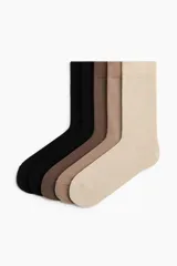 Pack de cinco pares de medias de punto fino en tonos neutros como negro, marrón y beige, con borde superior elástico.