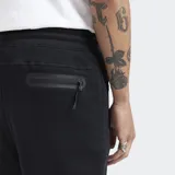 Pantalón de jogging negro con puños elásticos en los tobillos, cintura con cordón ajustable y bolsillos laterales con cierre.