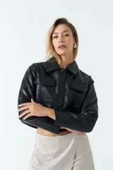 Sobrecamisa cropped de eco cuero negro, con cuello clásico, cierre frontal con botones y bolsillos frontales con tapa.
