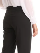 Pantalón de corte recto confeccionado en crepe, con cintura alta y detalle de botones metálicos dorados decorativos en los laterales. Presenta una silueta estructurada y elegante.