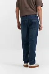 Pantalón de jean corte regular con tiro medio, diseño clásico de cinco bolsillos, cierre frontal con botón y bragueta, y pasacintos en la cintura.