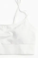 Bralette de diseño seamless, color blanco, con breteles finos ajustables, banda inferior acanalada y copas con relleno extraíble.