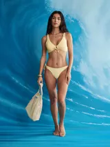 Top de bikini halter, color lila pálido con estampado de pequeños motivos en amarillo claro. Presenta un nudo central ajustable y tirantes finos que se anudan en la espalda y el cuello.