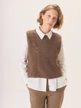 Chaleco de punto con textura jaspeada, cuello redondo y corte recto, diseñado para superponer sobre otras prendas.