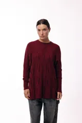Sweater de punto con textura en color bordó, de silueta relajada, cuello redondo y mangas largas con puños ajustados.