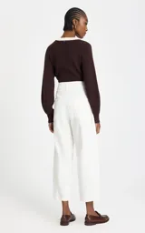 Pantalón de pana color blanco, corte balloon de talle alto y silueta ancha ligeramente ajustada en los tobillos. Cuenta con bolsillos y cierre frontal con botón y cremallera.