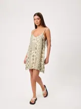 Vestido corto sin mangas en tono verde militar, con estampado de motivos marinos en beige y tirantes finos.