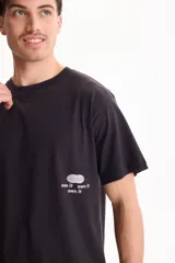 Remera negra de manga corta con corte semi boxy y estampado de texto en la espalda.