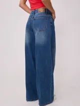 Jean de corte wide leg con tiro medio, confeccionado en denim de algodón en tono azul medio con efecto lavado.