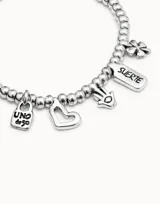 Pulsera plateada de eslabones con cuentas perladas y dijes colgantes con forma de candado, corazón, mano de Fátima, trébol de cuatro hojas y logo de la marca.