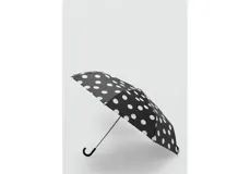 Paraguas plegable negro con estampado de lunares blancos y mango curvado de plástico negro.