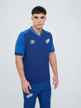 Remera polo oficial del Club Nacional de Football de color azul, con cuello en V y detalles en rojo y blanco, de manga corta y ajuste cómodo.