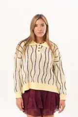Buzo de punto tipo polo en tono amarillo claro con diseño de ondas a rayas en tonos marrón y celeste. Presenta cuello clásico, cierre frontal parcial con botones y silueta relajada con mangas largas.