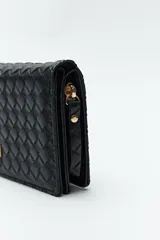 Billetera negra de símil cuero trenzado, con formato alargado y placa metálica dorada con el logo de la marca en el frente.