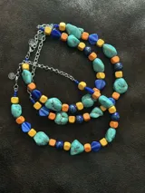 Collar de cuentas de piedras naturales, cristales checos y piedras reconstituidas en tonos turquesa, azul, naranja y amarillo. Se cierra con cadena de acero quirúrgico y ganchito para regular el largo.