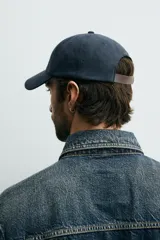 Gorra de seis paneles azul marino confeccionada en tejido de algodón, con bordado frontal en tono contrastante con la leyenda "button 84".
