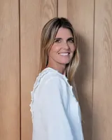Blusa de manga larga con diseño a rayas verticales, cuello redondo y detalle de volados en los hombros.