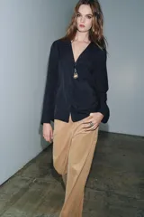 Camisa fluida de viscosa con cuello solapa de muescas, manga larga con puños y bolsillo de plastrón en el pecho. Cierre frontal con botones.