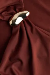 Top entallado sin mangas de punto elástico suave, color marrón. Presenta escote asimétrico con detalle metálico en un tirante y frunces laterales para un efecto drapeado.