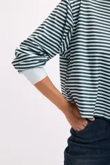 Remera de manga larga con diseño a rayas horizontales en color rojo y rosa, cuello redondo y puños elásticos.