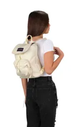 Mochila mini JanSport Highlands, color rosa pálido, con asa superior, bolsillo frontal con cierre y logo de la marca en el frente.