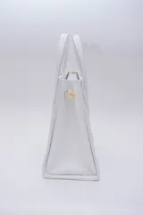 Cartera mediana de cuero blanco, con asa fija y correa regulable desmontable.