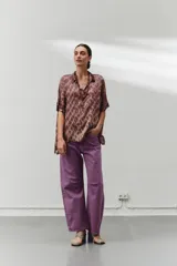 Blusa marrón con estampado abstracto, cuello camisero y botones en la parte delantera.