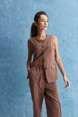 Pantalón de corte recto y holgado, color marrón, con costuras frontales verticales que estilizan la silueta.