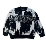 Buzo de punto con diseño abstracto en blanco y negro, con estampado gráfico estilo gótico en el pecho y detalles de roturas desgastadas en el tejido.