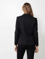 Blazer entallado marca Nanette, color negro, con cuello de solapa y cierre frontal de un solo botón. Cuenta con bolsillos delanteros y forro interno a tono.