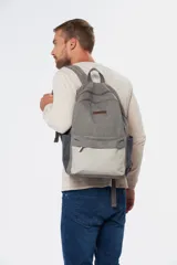 Mochila azul de lona tipo canvas con bolsillo frontal y logo de la marca en etiqueta de cuero.