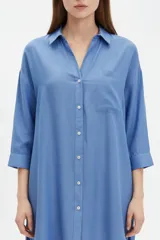 Camisa blanca de viscosa de corte oversize, con cuello camisero, cierre frontal de botones y bolsillo ojal en el pecho.