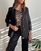 Blazer negro forrado con dos botones delanteros, bolsillos y hombreras.