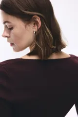 Remera de punto fino ajustada al cuerpo, con mangas largas, escote cuadrado pronunciado y tapeta frontal con botones decorativos.