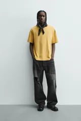 Camiseta de manga corta color crema, con cuello redondo y tejido texturizado con estructura.