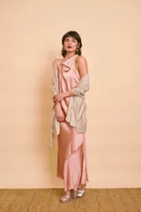 Vestido largo de satén color rosado, con escote halter drapeado, sin mangas y silueta fluida con tajo lateral.