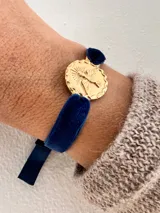 Pulsera con medalla dorada con la imagen del Espíritu Santo y cinta de terciopelo azul.