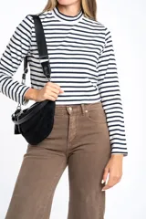 Polera de manga larga ajustada al cuerpo, con cuello mock (alto y cerrado). Presenta un patrón de rayas horizontales blancas y azul marino.